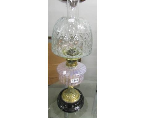 A Victorian oil lamp with glass font and later shade.
