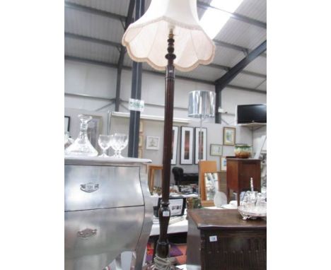 A mahogany standard lamp with shade.