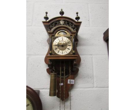 An oak and brass wall clock.