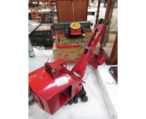 A boxed Mettoy typewriter and a Tri-ang crane.