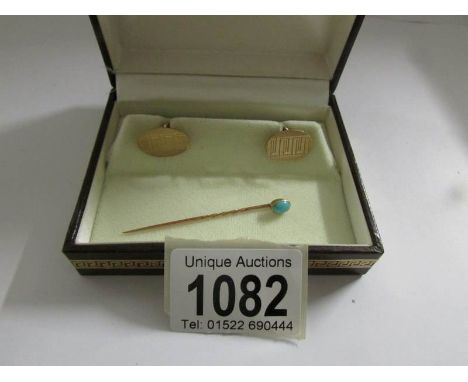 A boxed pair of 9ct gold cuff links and a gold coloured stick pin set turquoise