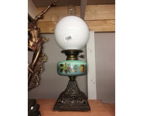 A Victorian oil lamp with painted glass font and complete with shade and chimney.