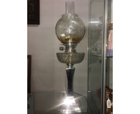 An Edwardian oil lamp with silver base complete with shade and chimney.