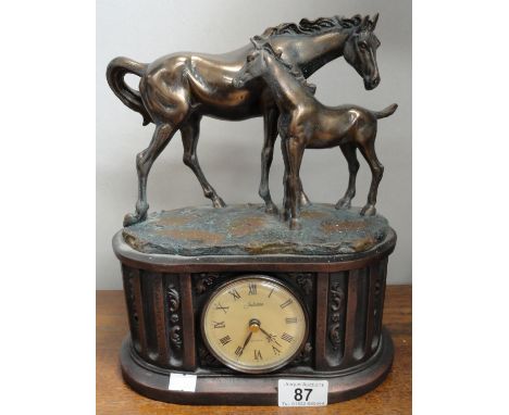 A mantel clock surmounted horse with foal.