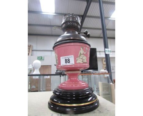 A pottery oil lamp base decorated with classical figures and with drop in glass font.