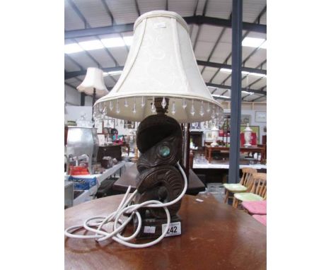 A carved wood table lamp with shade.