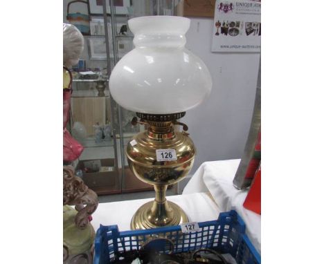 A brass oil lamp with shade but missing chimney.