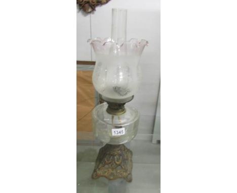 A Victorian oil lamp with original acid etched shade.