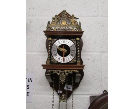 A brass and wood wall clock.