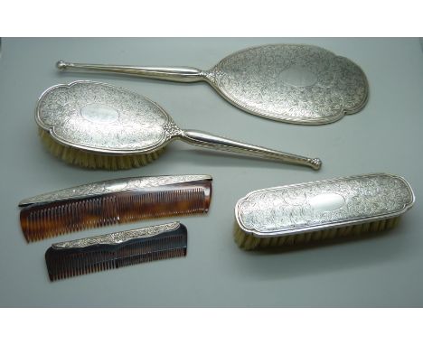 A four piece silver hand mirror set and one other silver comb