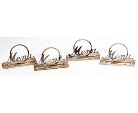 Four George V menu holders each with polished rectangular bases, pierced applied panels "Menu" and with ring supports, width 