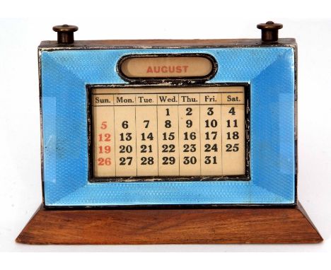 George V guilloche enamelled desk calendar, the rectangular frame on a flared base with an applied and engine turned mount wi