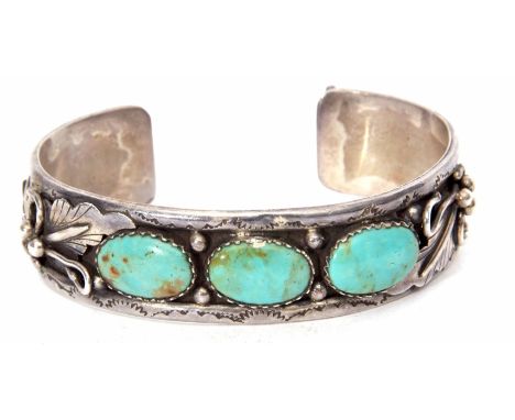 White metal and turquoise set torque bangle, an ornate leaf and bead design featuring three collet set oval turquoise stones,