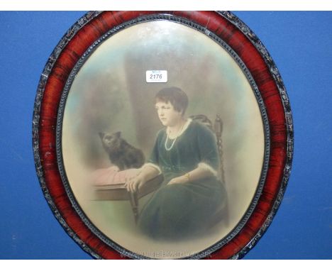 An oval framed coloured Print taken from an old photograph of a lady seated with dog by her side.