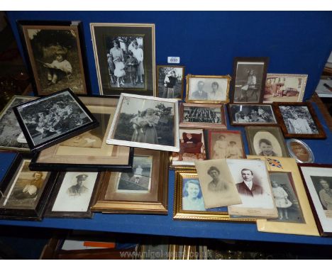 A box of framed early 20th century portrait photographs.
