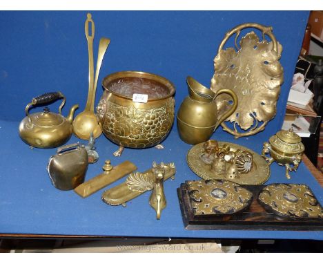 A box of mixed brass to include cow bells, teapots, two ladles, sliding book shelf etc.