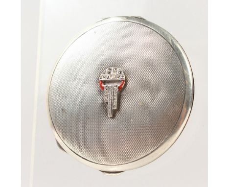 A SILVER ENGINE TURNED COMPACT.