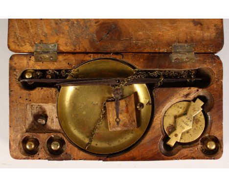A 19TH CENTURY SET OF BRASS SCALES AND WEIGHTS, in a walnut box. 8.5ins wide.