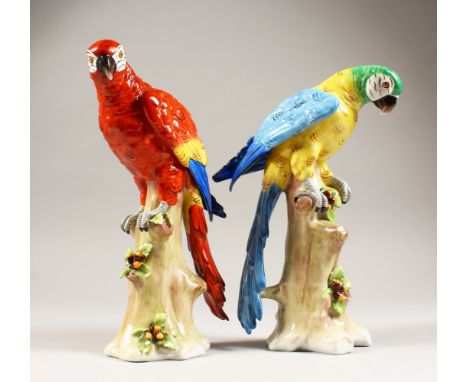 A PAIR OF SITZENDORF PARROTS, both modelled standing on a naturalistic tree stump. 9ins high.