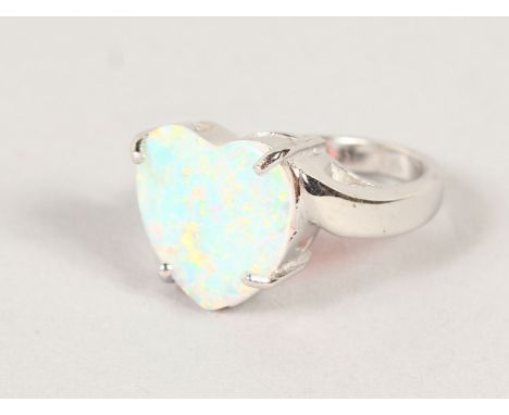 A SILVER AND OPAL HEART SHAPE RING.