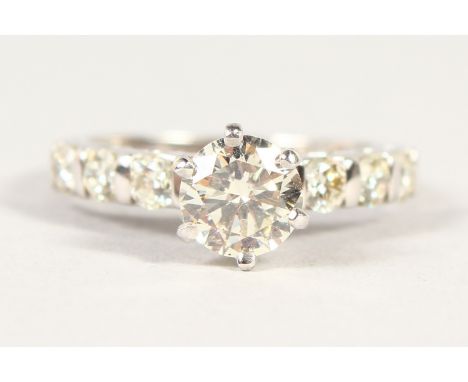 AN 18CT DIAMOND RING, THE CENTRAL STONE OF 1.25 cts flanked by six stepped diamonds to the shoulder.
