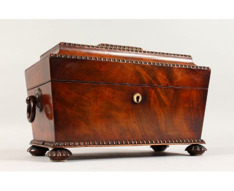 A VICTORIAN MAHOGANY SARCOPHAGUS SHAPED TEA CADDY with carved decoration, ring handles, the interior with two lidded compartm