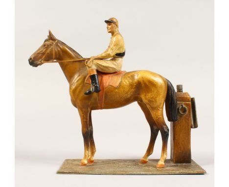 A PAINTED METAL FIGURE OF A JOCKEY ON A HORSE, as a lighter. 6.5ins high.