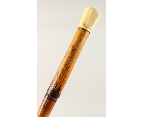 A 19TH CENTURY BAMBOO DAGGER CANE, with ivory pommel. 37ins long.