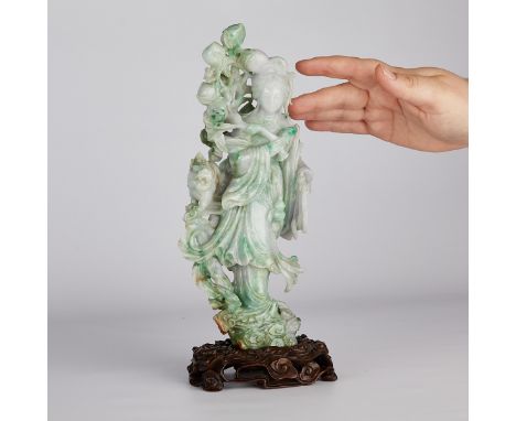 Chinese jade carving depicting a maiden with peaches and a small lion. Of a mottled spinach and white jade with a wooden base