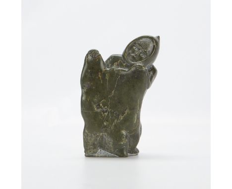 Large Native American Inuit jade carving depicting a man holding a pelt. With a Canada igloo sticker affixed along the unders