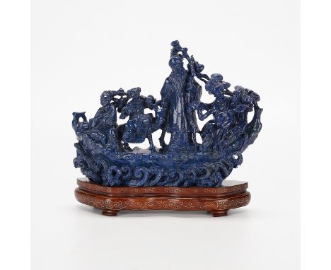 Chinese carved lapis lazuli sculpture depicting four figures including an immortal riding a ship. Attached to a wooden base a