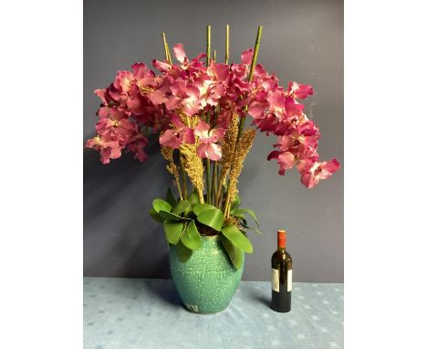 A large impressive faux flower arrangement,  purple orchids, with bamboo sticks and foliage, in large blue ceramic planter, 1