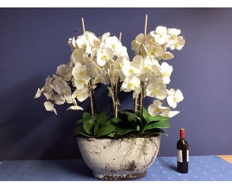 A large impressive faux flowers decorative statement piece, of white orchid arrangements,  in large ceramic style trough plan