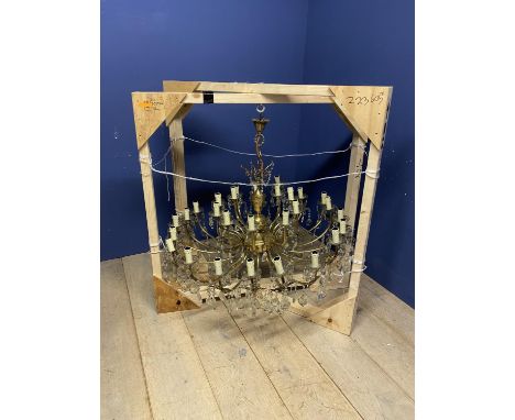 A large gilt metal and glass drop 30 branch double chandelier. Diameter 104cm. Drop 113cm. 