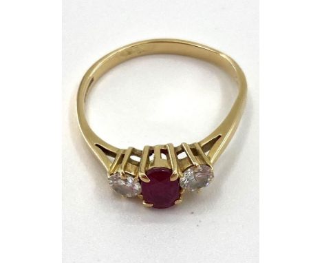 An 18ct gold ruby and diamond ring single oval free cut ruby with brilliant cut diamond accents , 2.72g, size Q 