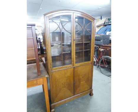 AN EDWARDIAN OAK DISPLAY CABINET, ON CUPBOARD BASE, THE TWO GLAZED DOORS ENCLOSING THREE SHELVES, THE BASE HAVING SOLID DIAMO