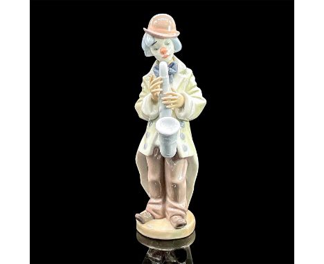 Glazed porcelain figure of a young clown in an oversized jacket holding a saxophone. Lladro backstamp. Artist: Francisco Cata