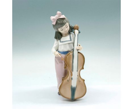 A glazed figure of a young girl playing a string instrument. Nao backstamp. Artist: Francisco CatalaIssued: 1992Dimensions: 3