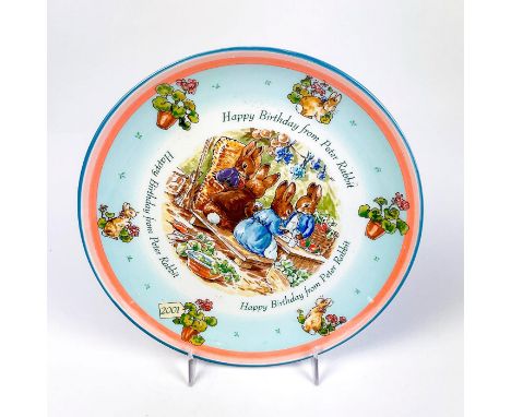 Collectors plate with an illustration of Peter Rabbit and his family and illustrations on surface with the year 2001.This ite