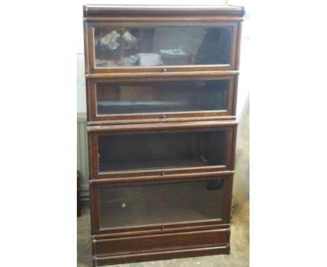 Globe Wernicke oak bookcase with 4 glazed drop doors, on a plinth base. 151.8cm x 86.5cm x 31.7cm overall. 