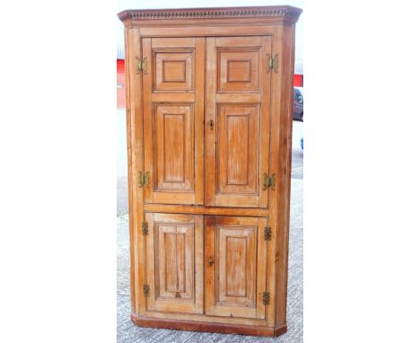 George III pine corner cupboard with a dentil cornice and 2 pairs of moulded panelled doors, on a plinth base, 191.7cm x 107.