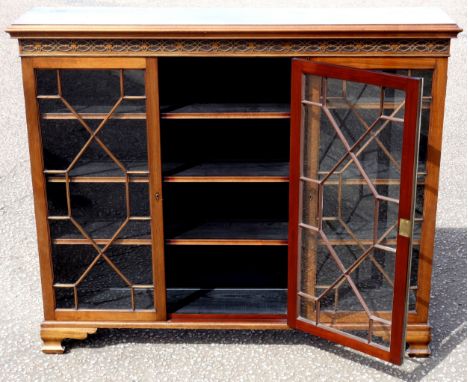 Edwardian mahogany bookcase with a carved blind fret frieze and three 13 glazed panelled doors on ogee bracket feet, H.121.5 