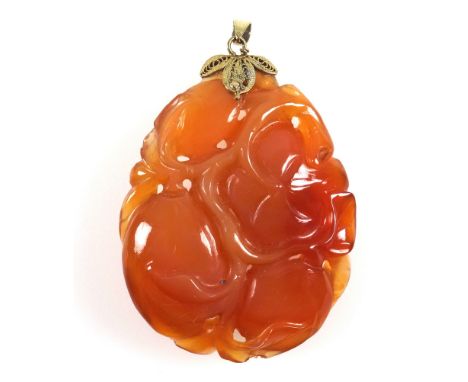 Oriental red jade ovoid pendant carved with a flower and fruit, with a yellow metal mount and suspender stamped “14K”, 5.4 x 