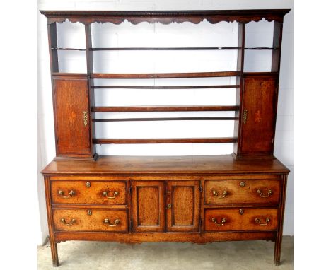Late 18th century elm dresser with open shelves flanked by 2 oval inlaid panel doors above, the Base with 2 panelled doors fl