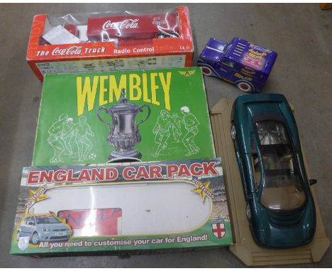 A Wembley board game, a Coca-Cola truck, an England car pack, a Maisto 1/18th scale model of a Jaguar XC220, tin and two book