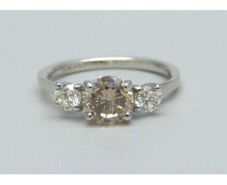 A hallmarked platinum, three stone diamond ring, champagne coloured centre diamond with two white diamonds either side, total