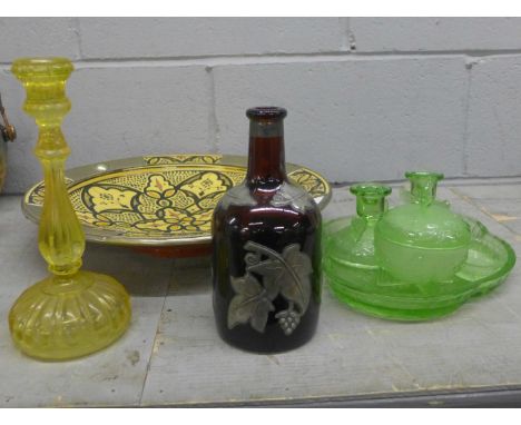 A Moroccan large shallow bowl, a brown glass bottle embellished with leaves, a lemon yellow glass candlestick and a uranium g