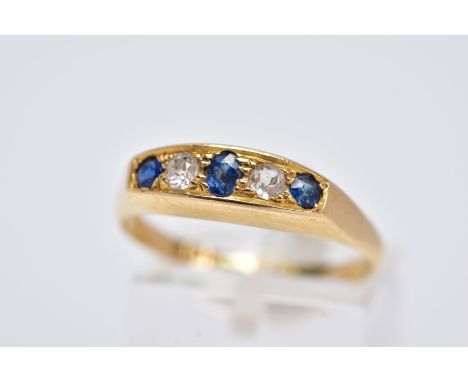 AN 18CT GOLD FIVE STONE RING, of a boat shape, set with a central oval cut blue sapphire interspaced with two old cut diamond