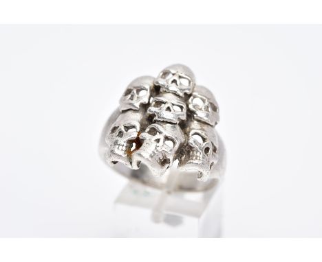 A GENTS SILVER SKULL RING, large ring designed with seven openwork skulls, stamped '925' Birmingham, ring size X, approximate