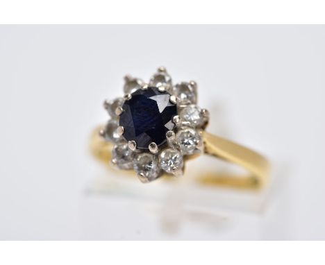 AN 18CT GOLD, SAPPHIRE AND DIAMOND CLUSTER RING, designed with a central oval cut blue sapphire, within a round brilliant cut